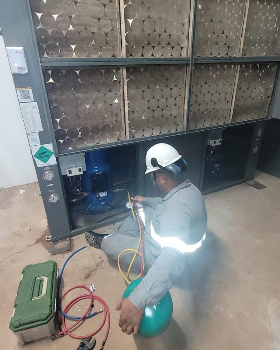 Deivid de EPI fazendo manutenção em climatizador industrial